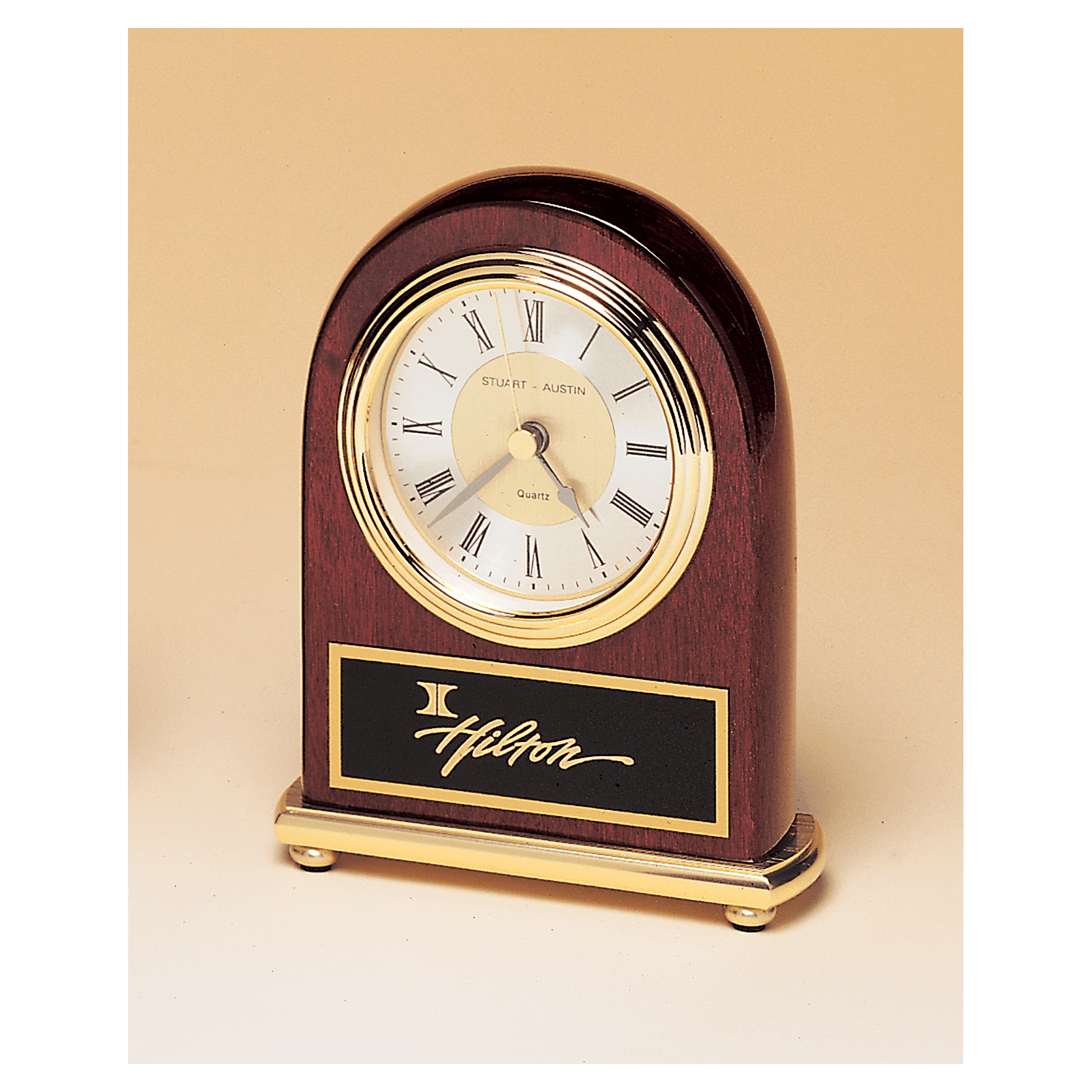 Arched rosewood clock with brass accents